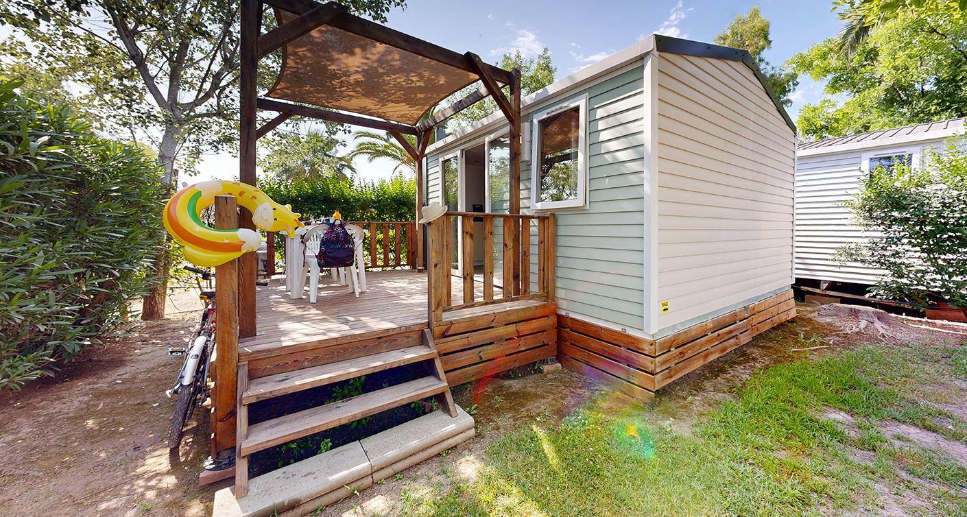 Buitenkant van de klassieke stacaravan van 20 m² voor 2 personen met overdekt terras, te huur op de 4-sterrencamping Le Neptune in de Hérault.