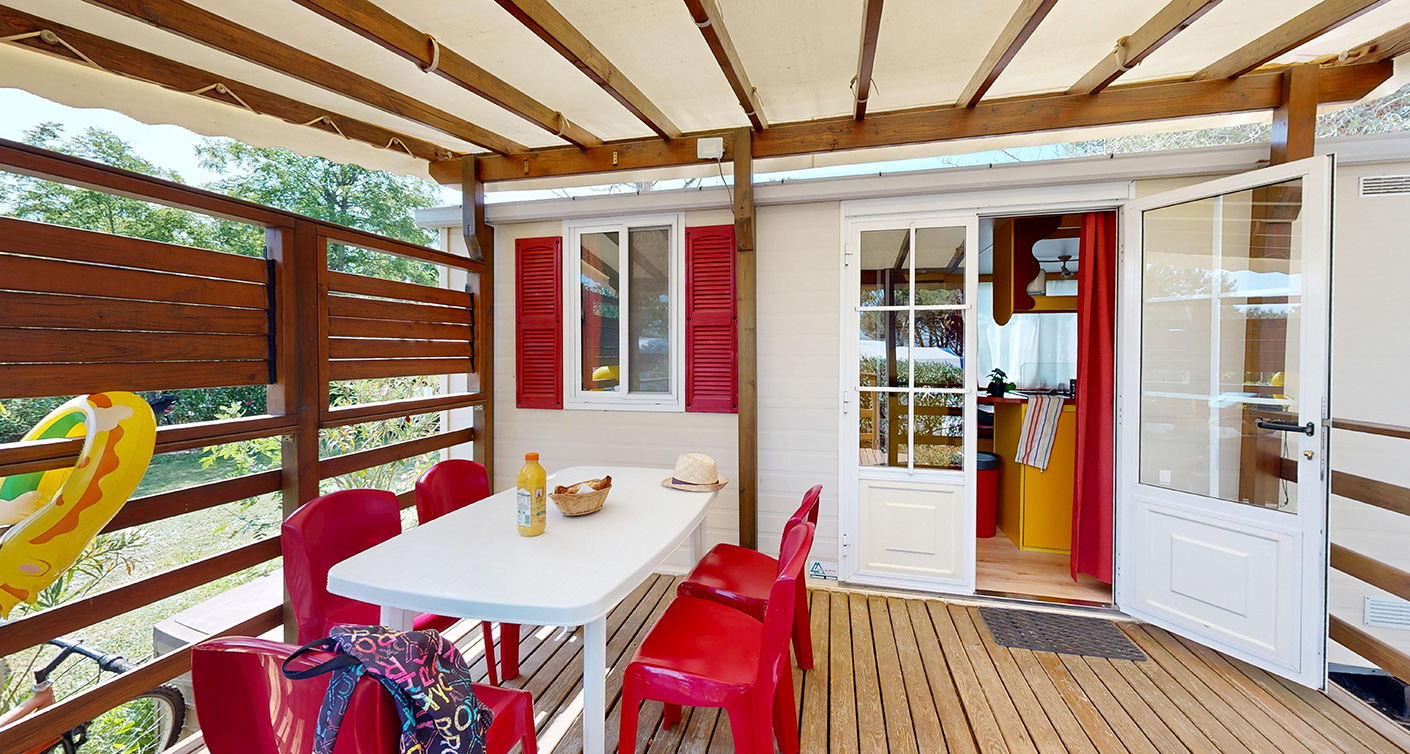 Buitenkant van de klassieke stacaravan van 25 m² voor 5 personen met half-overdekt terras, te huur op de 4-sterrencamping Le Neptune in de Hérault.