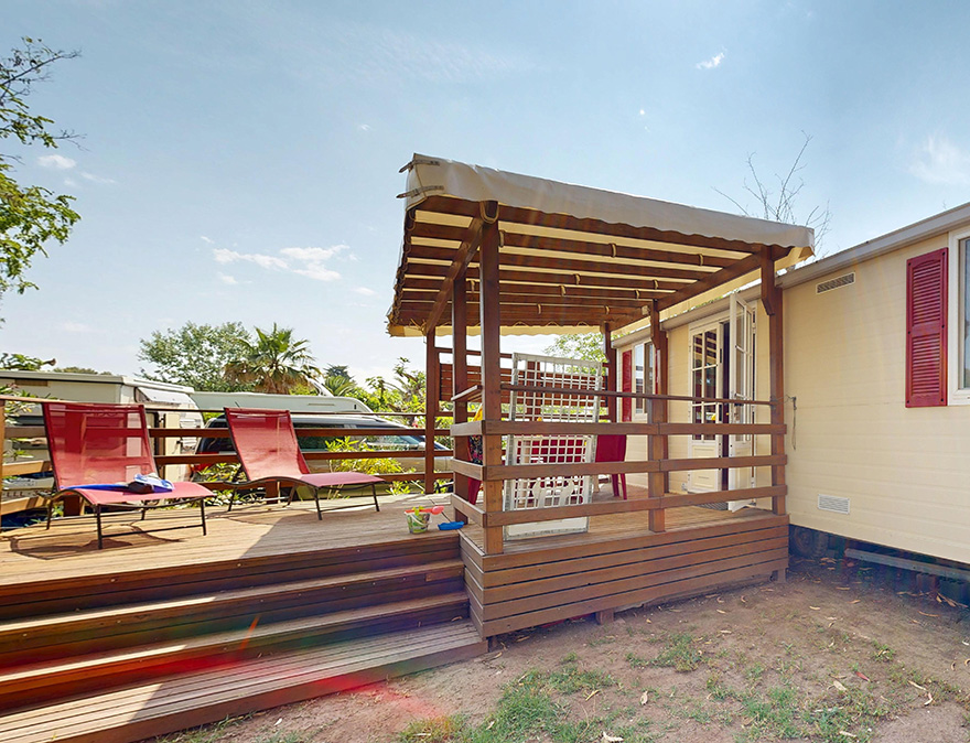 Het half-overdekte terras van de klassieke stacaravan van 25 m² voor 5 personen, te huur op de 4-sterrencamping Le Neptune in Agde.