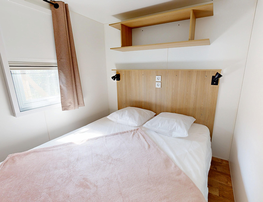 Zimmer mit Doppelbett im Mobilheim Premium 29 m² zur Miete auf dem 4-Sterne-Campingplatz Le Neptune im Departement Hérault