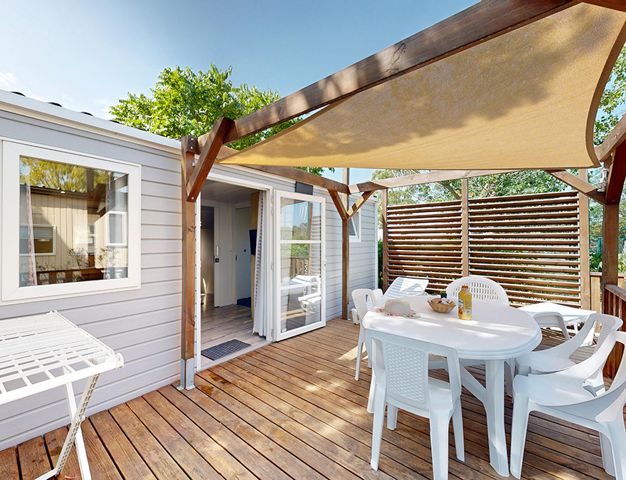Terrasse mit Gartenmöbeln und halbüberdachter Terrasse des Mobilheims für Personen mit eingeschränkter Mobilität Premium 33 m² für 4/6 Personen, zu mieten auf dem 4-Sterne-Campingplatz Le Neptune in Agde
