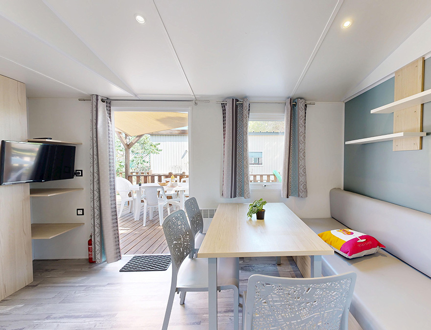 Wohnbereich des Mobilheims für Personen mit eingeschränkter Mobilität  Premium 33 m² für 4/6 Personen, zu mieten auf dem 4-Sterne-Campingplatz Le Neptune im Departement Hérault