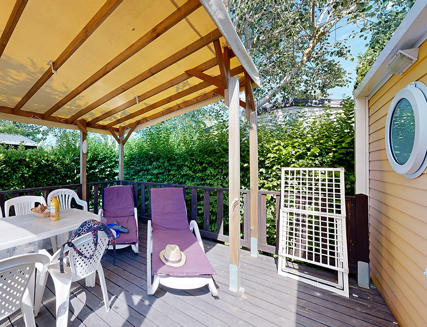 Half-overdekt terras met tuinmeubels van de stacaravan Privilège 33 m² te huur op de 4-sterrencamping Le Neptune in Agde